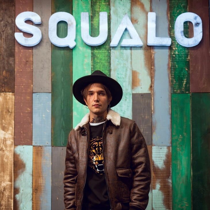 Man in front of the SQUALO wall, from our About Us story